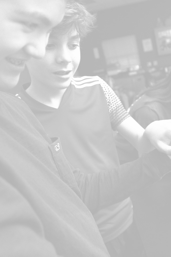 A group of focused Trinity middle school students working with microscopes in a science laboratory, with a female teacher assisting and guiding their exploration.